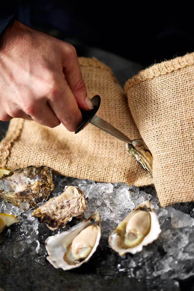 
            
                Load image into Gallery viewer, man shucking an oyster
            
        